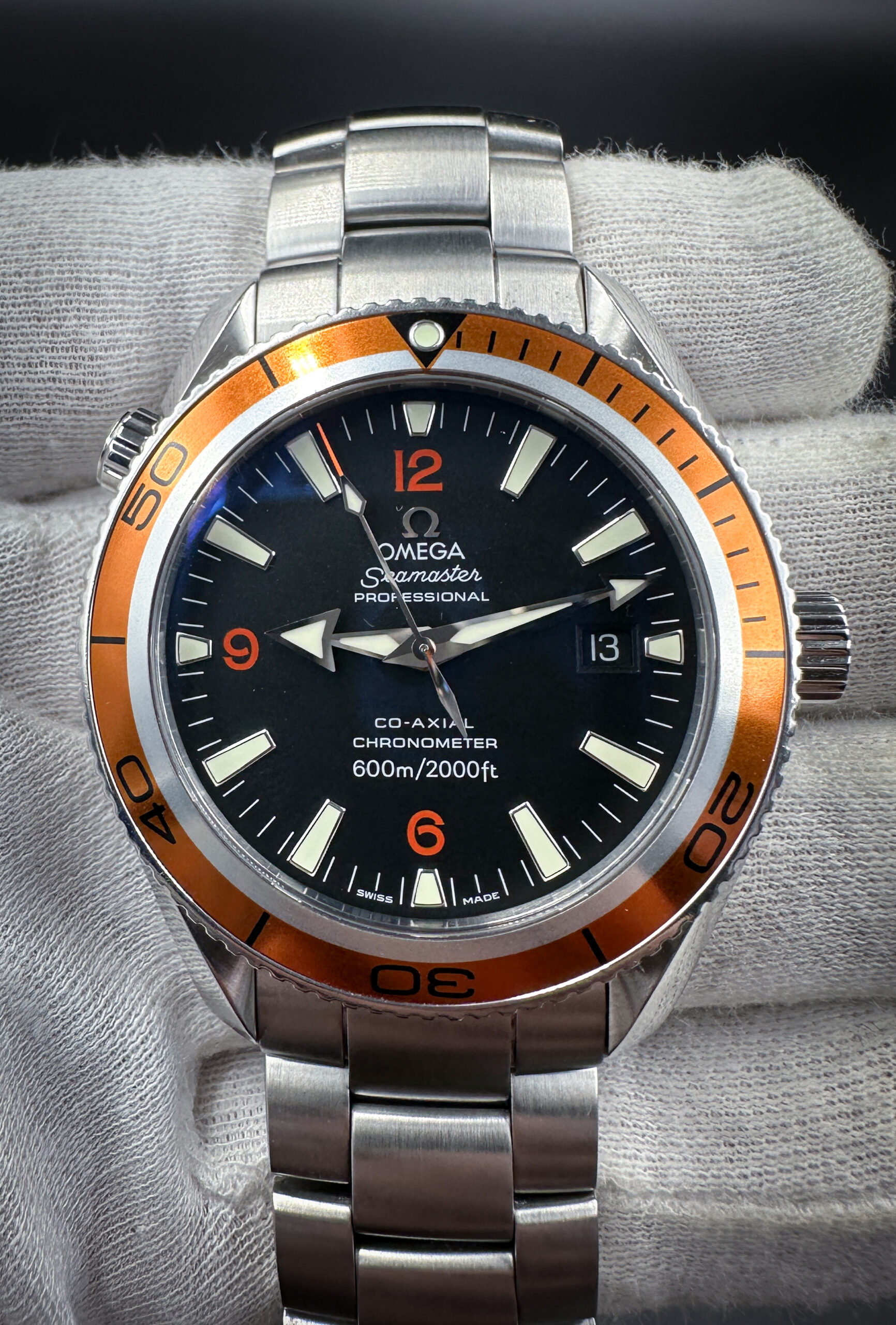 Omega Seamaster Planet Ocean 600m Ref. 2209.50.00 in a 42mm stainless steel case, featuring the Omega calibre 2500 automatic movement. This Omega features a matte-black dial and burnt-orange rotating bezel. This watch has been tested in good working order and is ready for wear or to be added to a collection.