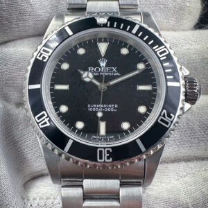 1997 Rolex Submariner 14060 No-Date (U Serial) in a 40mm stainless steel case, featuring the Rolex calibre 3000 automatic movement. This Submariner includes the outer box, inner case, green hang-tag with matching SN; calendar card, booklets, leather wallet, and punched warranty card. For provenance, the original bezel insert is also includes with this Submariner.