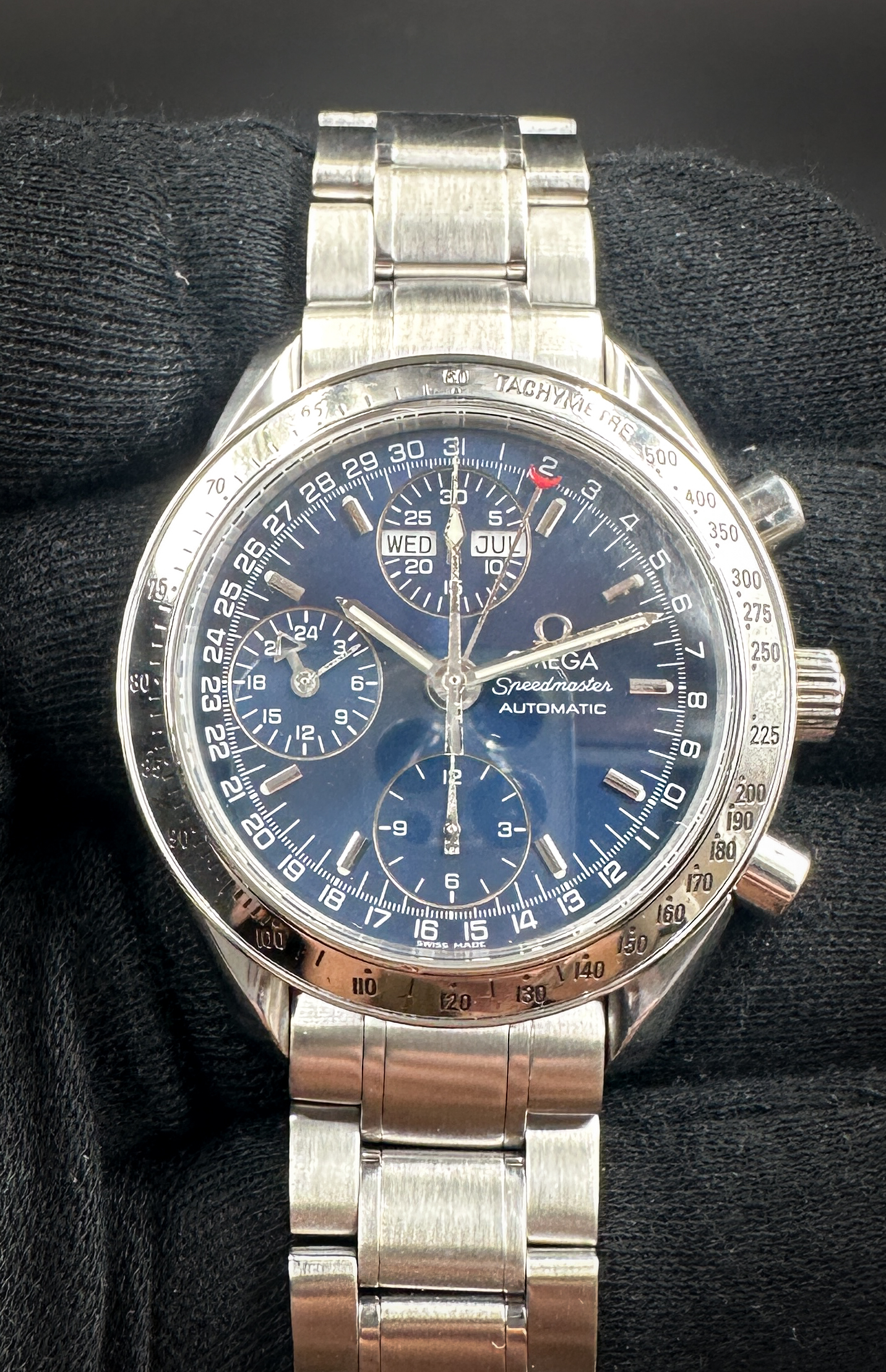 1998 Omega Speedmaster Day-Date Triple Calendar 3523.80 in a 39mm stainless steel case, featuring the Omega caliber 1151 automatic movement. This Speedmaster has been tested in excellent working order and is ready for wear or to be added to a collection. It includes the outer box; inner wooden case; travel box; operating instructions, leather wallet; and a TLC warranty card.