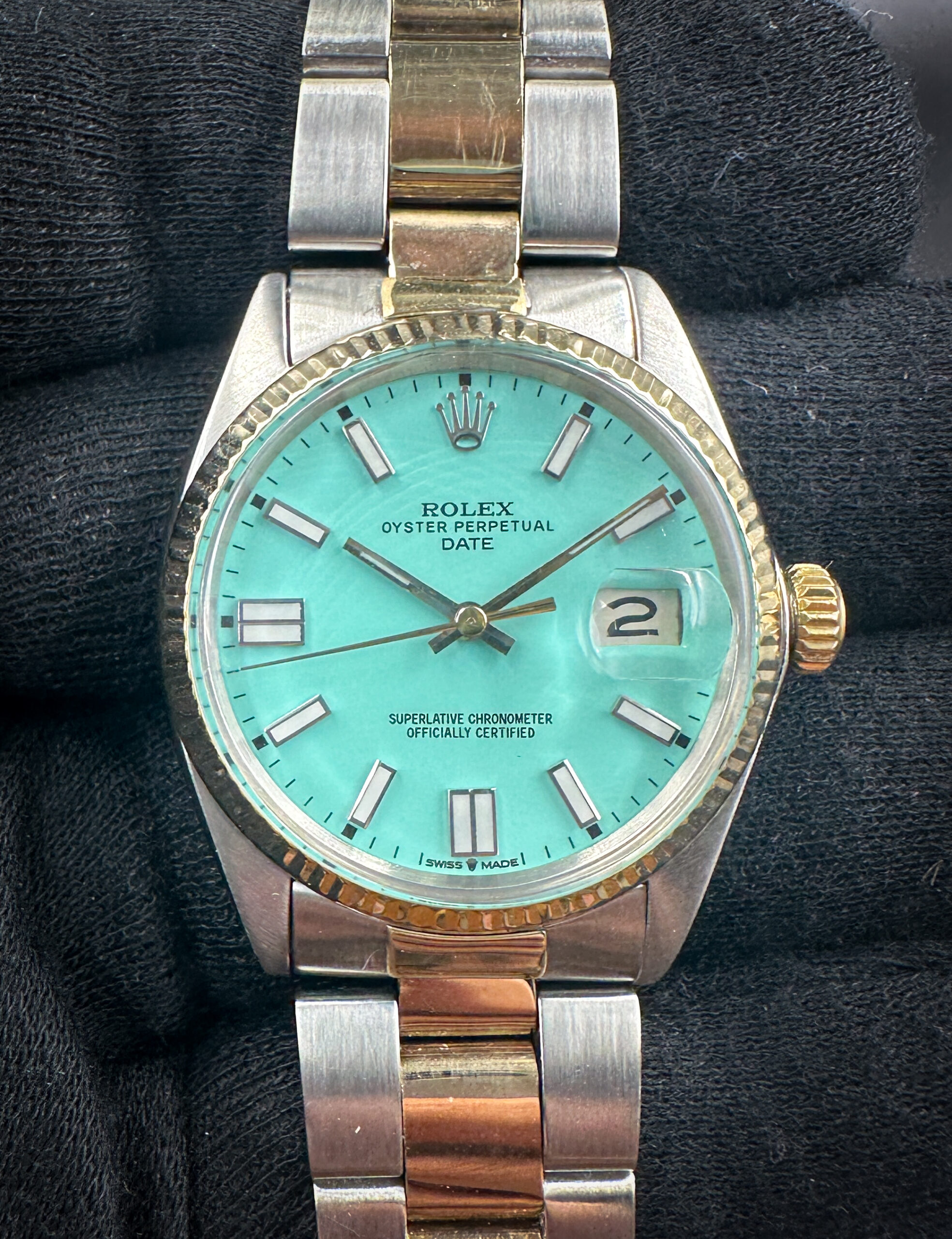 1969 Rolex 1500 Oyster Perpetual Date with a custom Tiffany-Blue dial, in a 34mm steel and yellow gold case, featuring the Rolex caliber 1570 automatic movement. The Rolex has been tested in wonderful working order and is ready for wear or to be added to a collection. Includes a new black watch roll from Wrist Wraith and a TLC warranty card.