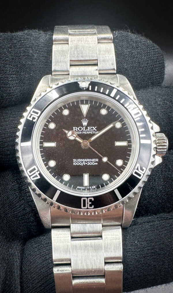 1996 Rolex Submariner 14060 (T-Serial) in a 40mm stainless steel case, featuring the Rolex calibre 3000 automatic movement. This Submariner features and unique tropical dial and includes: the outer box, inner case, folder, Submariner booklet; Oyster booklet; Factory Service Booklet; seal hangtag; original bezel insert; and TLC warranty card.