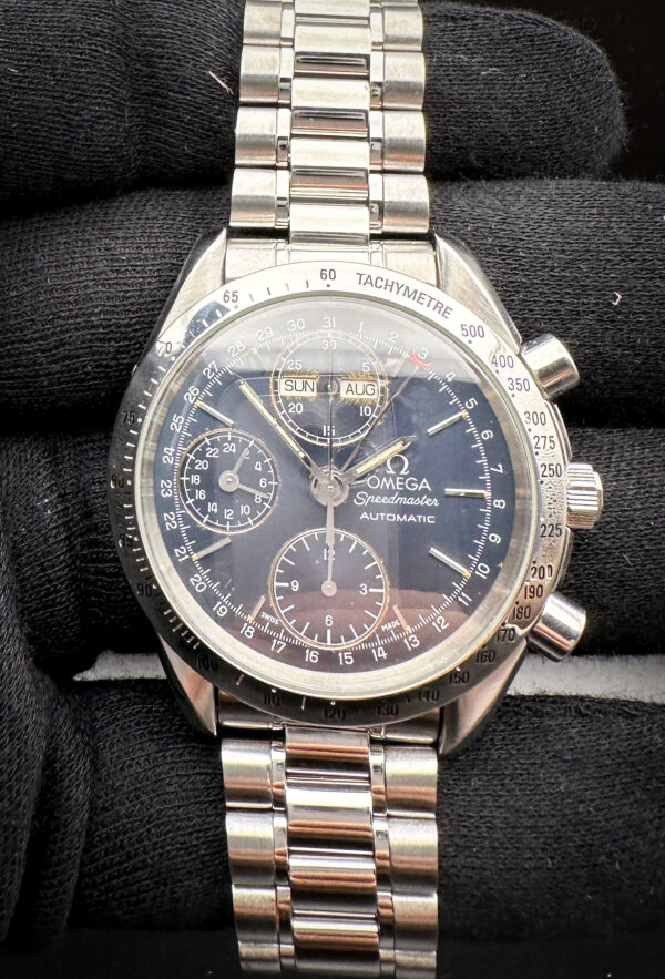 1993 Omega Speedmaster Day-Date Triple Calendar 3521.80 in a 39mm stainless steel case, featuring the Omega caliber 1150 automatic movement. This Speedmaster has been tested in excellent working order and is ready for wear or to be added to a collection. It includes the outer box, inner wooden case, wallet, booklet, travel case, and TLC Warranty card. Caseback Serial Number: 54761XXX