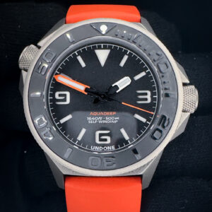 Undone Aquadeep Signal Orange Automatic in a 43mm titanium case, powered by the Seiko NH35A automatic movement. Includes the original box, warranty card (2023), and QR code user manual.