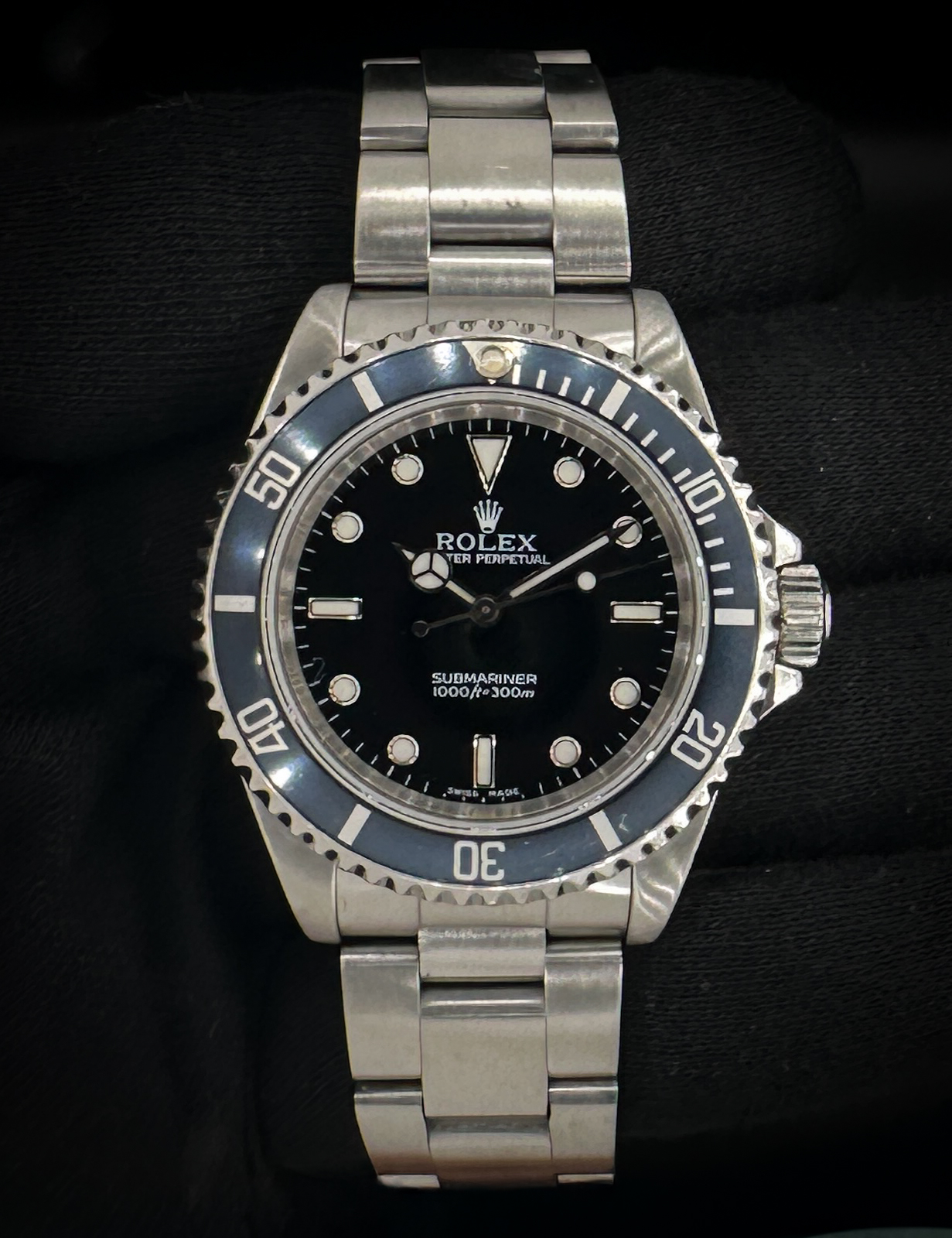 1995 (W-Serial) Rolex Submariner 14060 in a 40mm stainless steel case, featuring an original Blue-Ghosted bezel. This watch includes a new Wrist Wraith watch roll, and a TLC warranty/authentication card. Serial Number: W783XXX