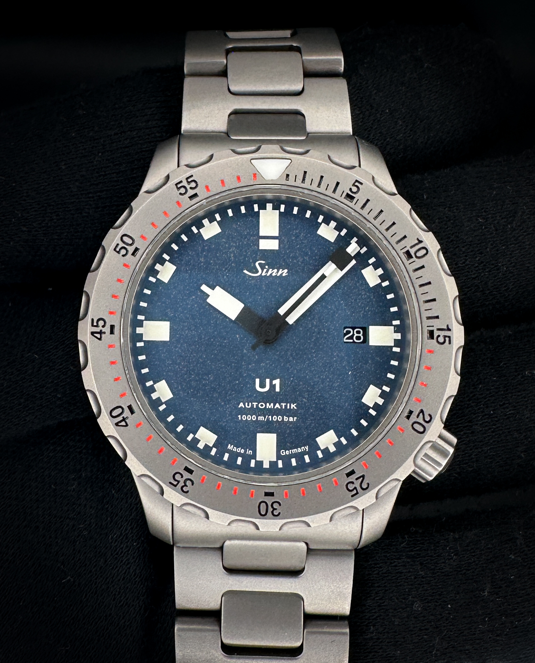 2019 Sinn U1 1010.18484 in a 44mm stainless steel case. This Sinn includes: outer box; inner case; band tool; link tool; instruction booklet; three extra links; and warranty card. The Sinn U1 is a robust German diving watch known for its case made from high-strength German submarine steel, which is highly resistant to seawater and corrosion. It is water-resistant to 1,000 meters (100 bar) and certified to European diving standards. Key features include a 44mm case, a high-contrast dial, and a crown positioned at the 4 o'clock position to avoid pressure on the back of the hand. 