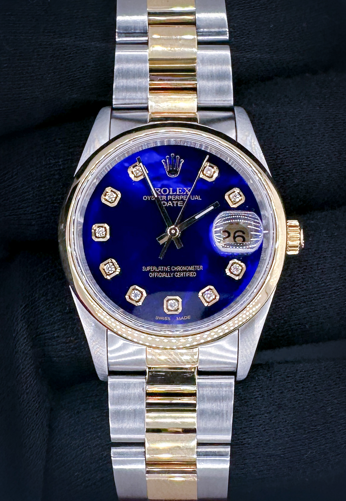 Vintage 1991 Rolex Oyster Perpetual Date 15203 in a 34mm yellow gold and stainless steel case, featuring a custom diamond-marker blue-pearl dial, powered by the Rolex caliber 1570 automatic movement. This Rolex has been tested in excellent working order and includes a new Wrist Wraith travel case, and the TLC warranty and authentication card.  Case Serial Number: X964XXX