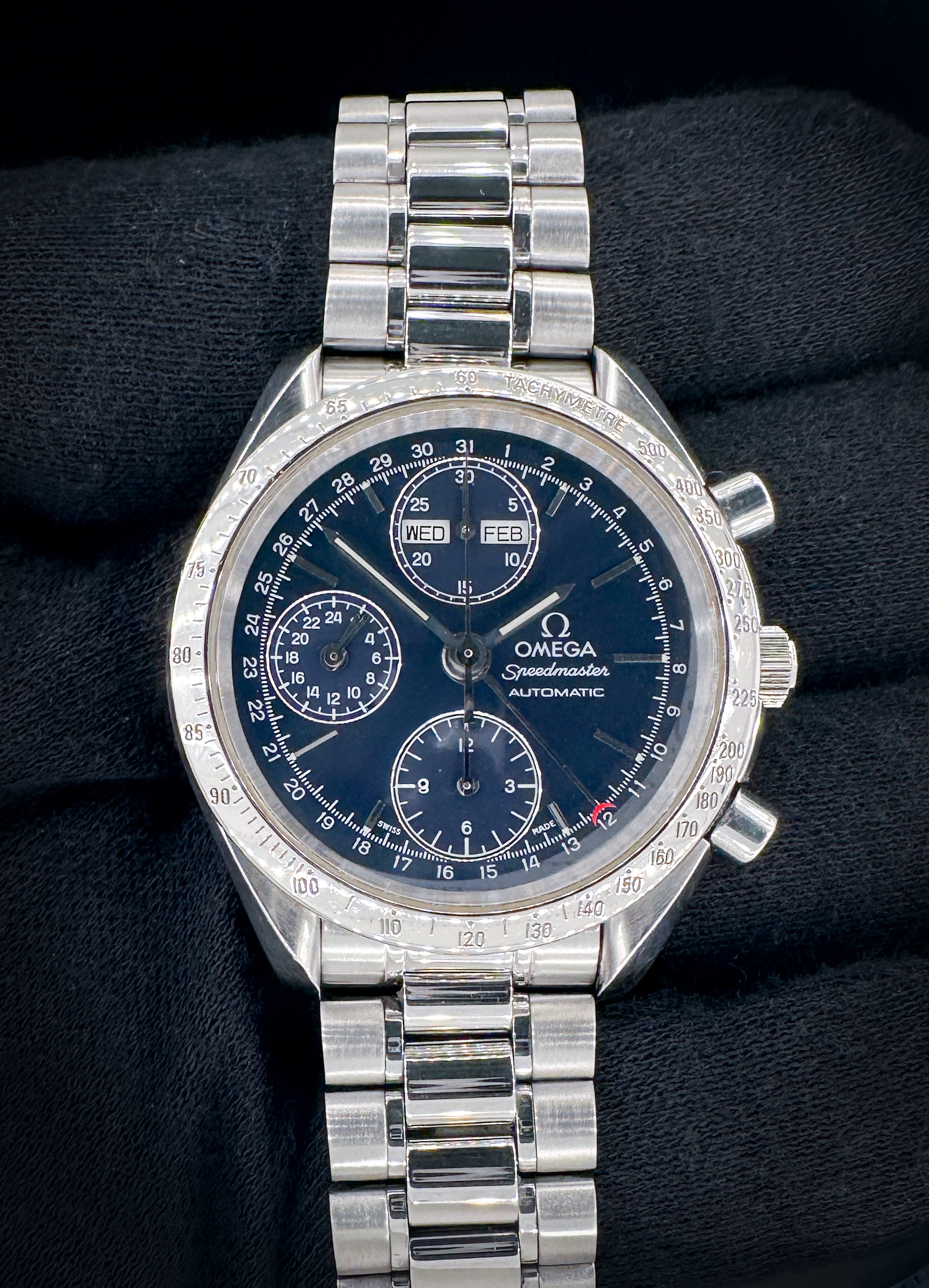 Vintage c. 1993 Omega Speedmaster Day-Date Triple Calendar 3521.80 in a 39mm stainless steel case, featuring the Omega caliber 1151 automatic movement. This Speedmaster has been tested in excellent working order and is ready for wear or to be added to a collection. Includes the Omega outer box, inner wooden case, travel case, instruction book, wallet, and TLC warranty card. Caseback Serial Number: 55985XXX