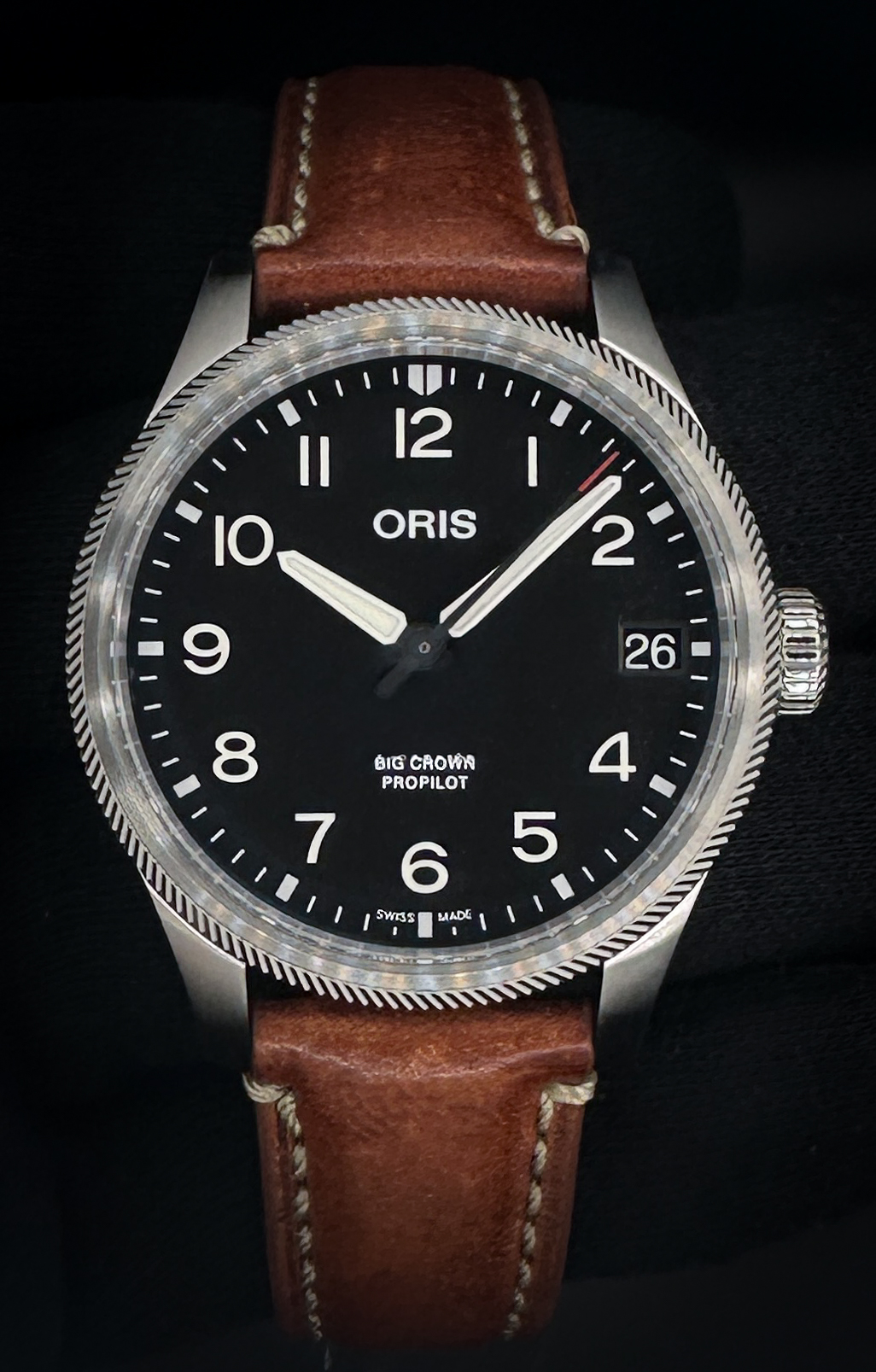 New, Unworn Oris Big Crown ProPilot Big Date 01 751 7761 4164. Includes: outer box, inner case, folder, service centres booklet, instruction booklet, and warranty card.  The Oris Big Crown ProPilot Date is a modern pilot’s watch engineered for clarity, durability, and everyday versatility. This reference features a commanding 41mm stainless steel case paired with a clean, legible black dial, highlighted by bold luminous Arabic numerals and cathedral-style hands for exceptional readability in all conditions. An oversized screw-down crown provides effortless operation, while the Swiss automatic Oris Calibre 751 movement delivers dependable performance with a 38-hour power reserve. The watch is fitted to a rugged green textile strap with leather lining, reinforcing its aviation tool-watch heritage while offering exceptional comfort and wearability.