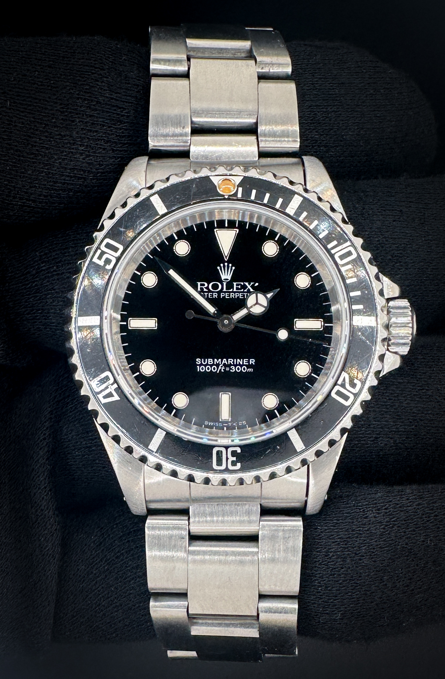 1995 (W-Serial) Rolex Submariner 14060 in a 40mm stainless steel case, powered by the Rolex caliber 3000 automatic, featuring a patina-pip bezel. This Rolex was serviced 07 January 2026. Includes: Outer Box; inner case; polishing cloth; hang-tag (matching serial); Oyster Booklet; Submariner Booklet; leatherette wallet; warranty booklet; and Punched Warranty Card.  Accuracy Tested: +/- 1 Spd / 281 Amplitude / .2ms Beat Error Serial Number: W196XXX