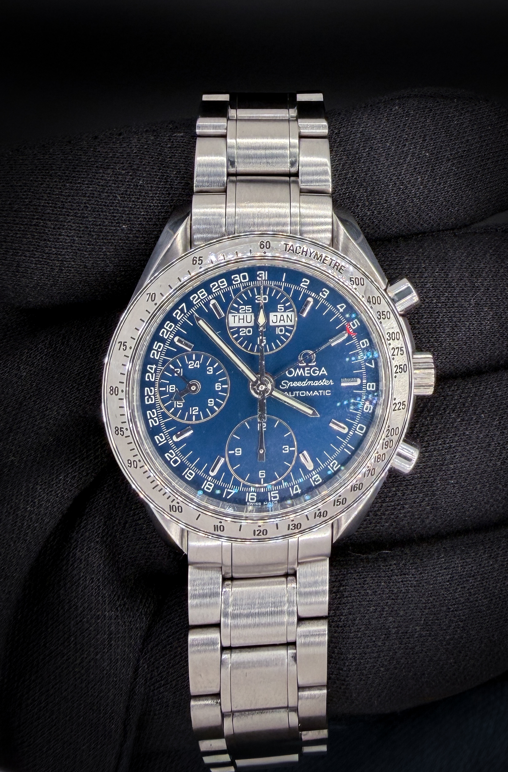 Vintage c. 1998 Omega Speedmaster Day-Date Triple Calendar 3523.80 in a 39mm stainless steel case, featuring the Omega caliber 1151 automatic movement. This Speedmaster was serviced January 2026 and includes an Omega Wood Case; Omega Travel Box; and TLC Warranty/Authentication card.  Accuracy Testing: +2 SPD / 294 Amplitude / .3ms Beat Error Caseback Serial Number: 57005XXX