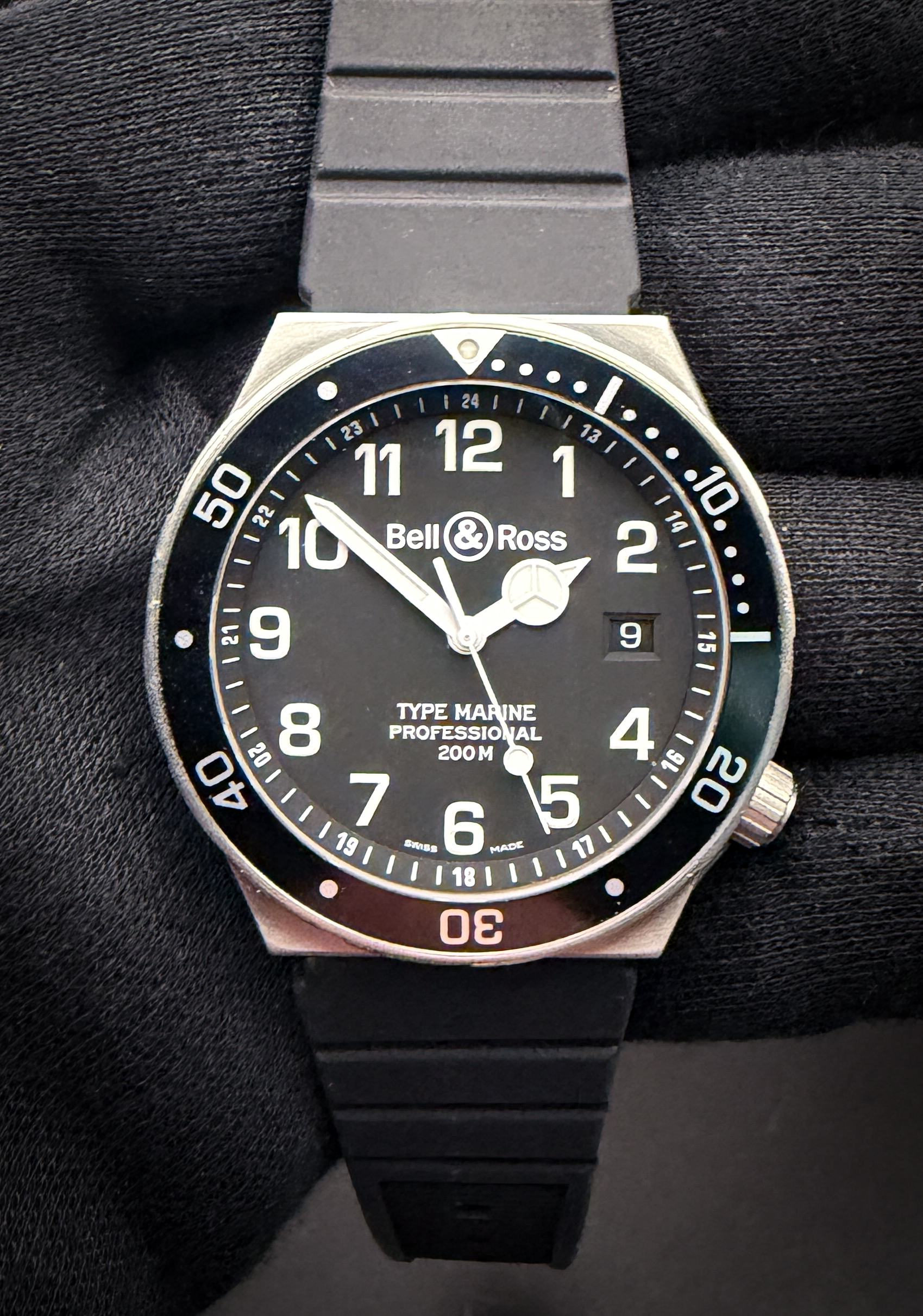 Bell & Ross Type Marine Professional 200M reference 410S, in a 40mm stainless steel case, featuring a matte black dial with oversized luminous Arabic numerals, internal 24-hour scale, unidirectional timing bezel, and the distinctive Mercedes-style hour hand that defines the early Type Marine series. The brushed stainless steel case delivers the clean utilitarian design language Bell & Ross became known for during the brand’s formative years, while the black rubber strap gives the watch a purposeful and comfortable wrist presence. Powered by the reliable ETA 955.612 quartz movement, this Type Marine blends military-inspired legibility with true everyday practicality. Serial Number: 410S10579