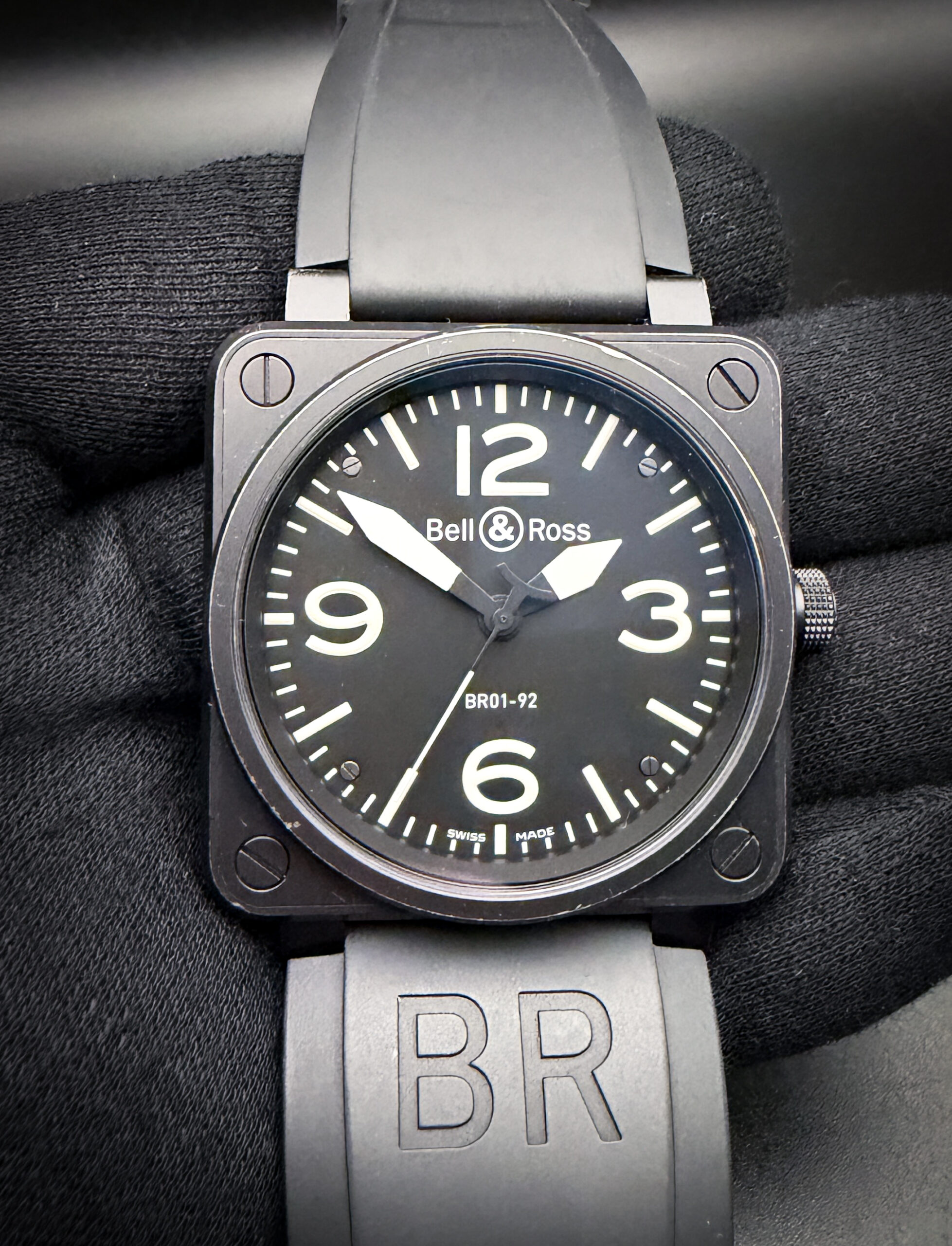 Bell and Ross BR01-92-S Diver in a 46mm square case, featuring the ETA 2892 automatic movement. This BR has been tested in excellent working order and is ready for wear. Includes a New Wrist Wraith watch roll, and a TLC Warranty/Authentication Card. The crystal is clear and free of scratches or mars. The original dial and hands are pristine with no stains or discoloration. Overall the case is in good condition, with no significant scratches or dents. The black PVD coating has light wear along the case and bezel edges, giving this watch an excellent military appearance. This BR is paired with the original black rubber strap with black buckle.