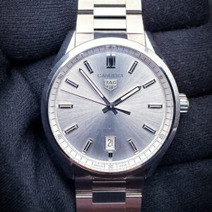 TAG Heuer Carrera Date reference WBN2111.BA0639, featuring a silver sunburst dial with applied polished baton hour markers, faceted hands, and a framed date aperture at 6 o’clock. The finely brushed and polished stainless steel case measures 39mm and is paired with the original stainless steel bracelet, delivering the clean proportions and understated motorsport-inspired styling that have defined the Carrera collection since its introduction in 1963. Powered by the TAG Heuer Calibre 5 automatic movement, this reference blends modern reliability with the timeless minimalist design language that has made the Carrera one of the brand’s most enduring collections.