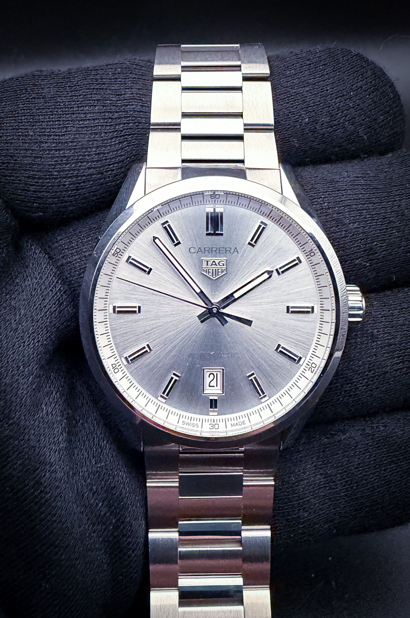 TAG Heuer Carrera Date reference WBN2111.BA0639, featuring a silver sunburst dial with applied polished baton hour markers, faceted hands, and a framed date aperture at 6 o’clock. The finely brushed and polished stainless steel case measures 39mm and is paired with the original stainless steel bracelet, delivering the clean proportions and understated motorsport-inspired styling that have defined the Carrera collection since its introduction in 1963. Powered by the TAG Heuer Calibre 5 automatic movement, this reference blends modern reliability with the timeless minimalist design language that has made the Carrera one of the brand’s most enduring collections.
