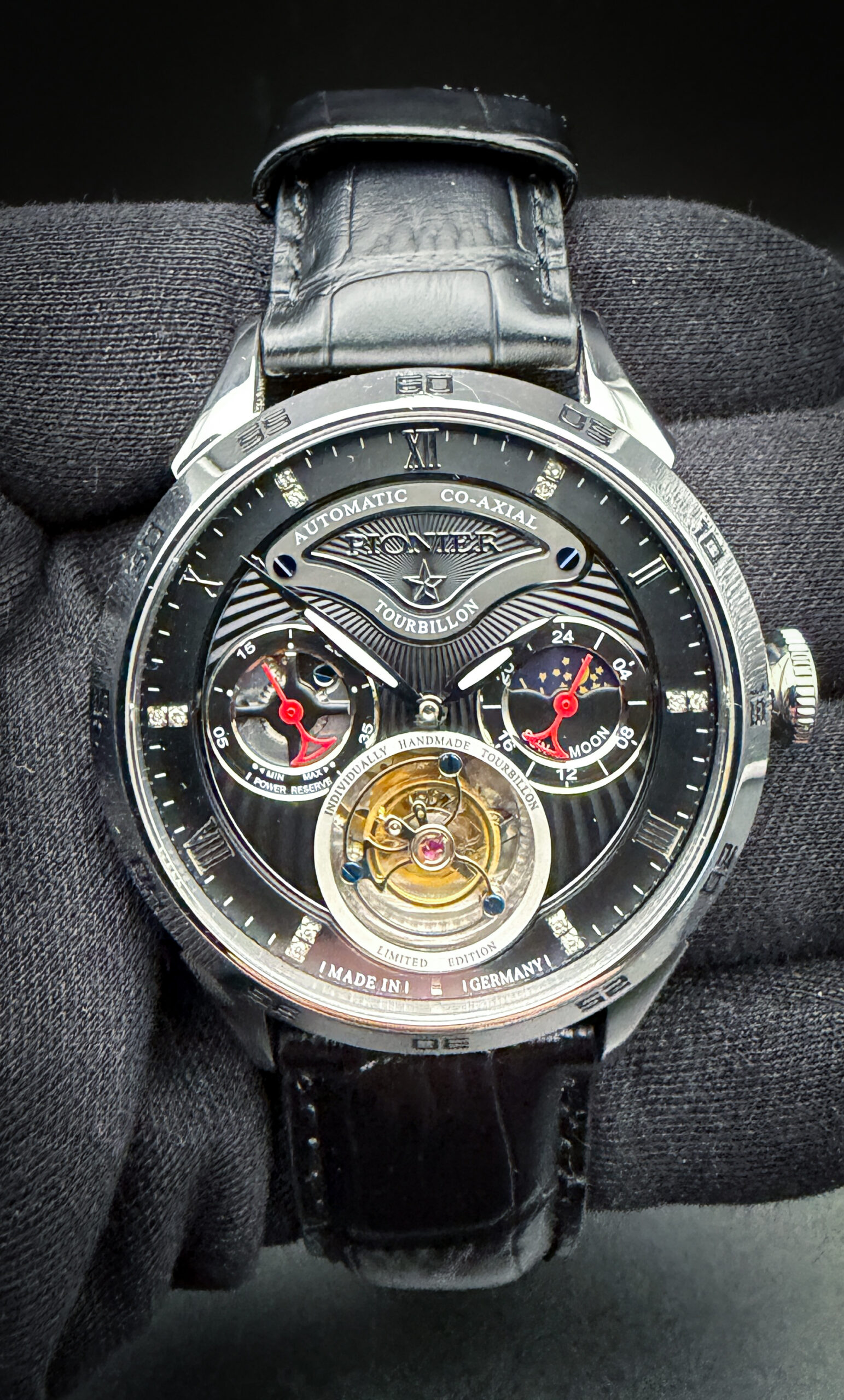 Tufina Pionier Germany CM-902-1, Limited Edition 052/100, in a 44mm stainless steel case, powered by the in-house Co-Axial Tourbillon automatic movement. This watch has been tested in excellent working order and is ready for daily wear or to be added to a collection. Includes the outer box; inner case; instruction booklet; story card; and warranty card dated 02.03.2021.  This watch features open works; power indicator; and sun & moon phase. 