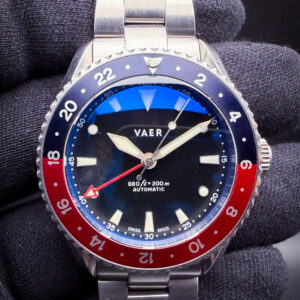VAER G7 Meridian Pepsi VA-G7-01 in a stainless steel case, featuring the classic blue-and-red “Pepsi” GMT bezel configuration that pays direct homage to the iconic mid-century travel watches pioneered by Rolex’s legendary GMT-Master references. Designed as VAER’s modern interpretation of the traditional dual-time sports watch, the G7 Meridian blends vintage airline-era styling with contemporary everyday durability, including a clean matte dial, highly legible luminous markers, and an integrated GMT hand for tracking a second time zone. The watch is powered by the Swiss Sellita SW330-2 automatic GMT movement, offering true mechanical traveler functionality with proven reliability and smooth operation. Paired with a versatile stainless steel bracelet and balanced proportions, the G7 Meridian Pepsi captures the spirit of classic aviation tool watches while delivering an approachable modern alternative inspired by one of the most recognizable GMT designs ever created.