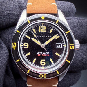 Spinnaker Fleuss SP-5055-01 in a 43mm stainless steel case with a substantial vintage-inspired dive-watch profile, drawing clear design influence from the legendary Blancpain Fifty Fathoms and other early skin-diver watches of the 1950s. The Fleuss combines classic tool-watch aesthetics with modern everyday wearability through its domed crystal, oversized luminous hands and markers, internal-style minute track, and clean high-contrast dial layout that echoes the golden age of recreational diving watches. Powering the watch is the reliable Japanese Seiko NH35 automatic movement, known for its durability, hacking functionality, and dependable daily performance. Paired with a matching stainless steel bracelet and robust wrist presence, the SP-5055-01 delivers the vintage charm and military-inspired styling of early professional dive watches while remaining an approachable and capable modern automatic diver.