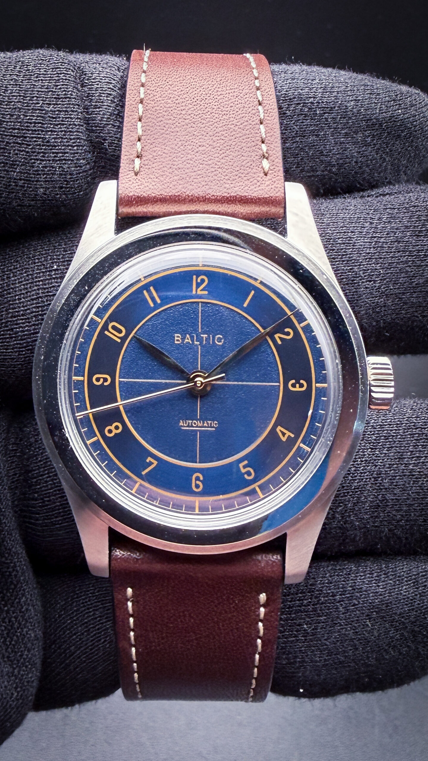 Baltic HMS BA-HMS002-001 in a polished stainless steel case measuring 38mm in diameter with a compact lug-to-lug profile and slim vintage-inspired proportions, showcasing the brand’s signature blend of mid-century European dress-watch styling and modern mechanical reliability. Inspired heavily by classic sector-dial watches of the 1940s and 1950s — particularly the elegant proportions and minimalist execution associated with vintage Patek Philippe, Longines, and Universal Genève references — the HMS captures the restrained sophistication of post-war Swiss watch design through its stepped case architecture, brushed silver sector dial, applied markers, and domed hesalite-style crystal. Powering the watch is the reliable automatic Miyota 8315 movement, offering contemporary durability while maintaining the charm and proportions of true vintage-inspired watchmaking. With its slim profile, clean typography, and timeless dress-casual versatility, the Baltic HMS BA-HMS002-001 delivers an accessible modern interpretation of the golden era of classic Swiss horology.