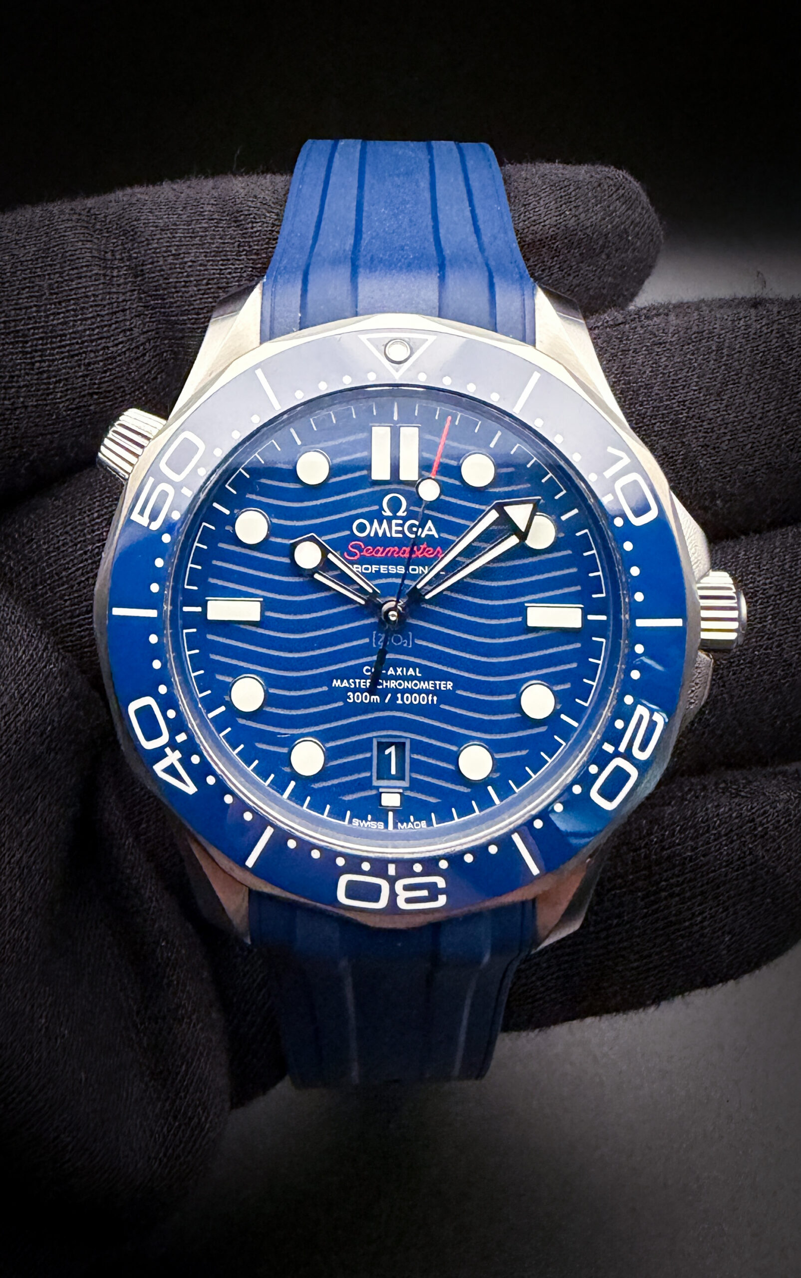 The Omega Seamaster Diver 300M Ref. 210.30.42.20.03.001 is a modern luxury dive watch housed in a 42mm stainless steel case and powered by Omega's Master Chronometer Caliber 8800 automatic movement. Featuring a striking blue ceramic wave-pattern dial, matching ceramic bezel, 300-meter water resistance, and the iconic helium escape valve, this Seamaster blends professional-grade performance with the refined styling that has made the model a favorite of collectors and James Bond enthusiasts alike. This Omega includes both the Blue rubber strap with double fold buckle; and the Omega stainless steel bracelet with micro-adjustment buckle. The bracelet is fully linked.  Serial Number: 84275XXX This Seamaster includes the full kit: Outer Box, Inner wooden case; instruction book; leatherette wallet, hang-tag, chronometer card; pictogram card; and warranty card (7-10-24); as well as the original sales receipt 