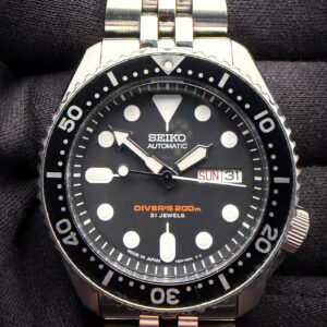 Seiko Diver's 200m 7S26-0020 SKX007 featuring the black bezel, power by the Seiko 7S26 automatic movement. This Diver features the English and Arabic day-wheel. This Seiko has been tested in good working order and is ready for daily wear. Includes the outer box, inner box, hang-tag, instruction book, original rubber strap, and aftermarket jubilee-style stainless steel bracelet  Case Serial Number: 4933847