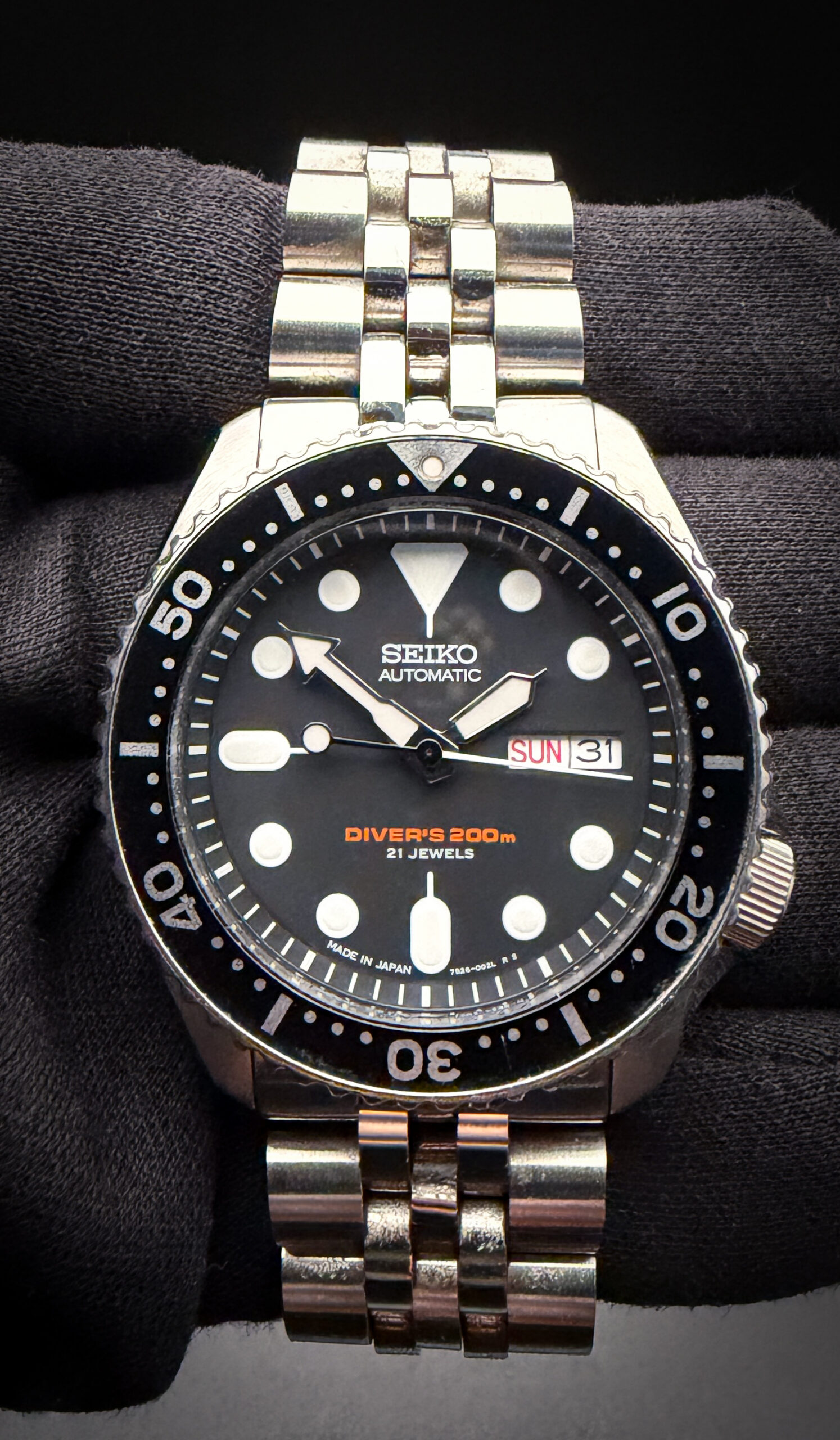 Seiko Diver's 200m 7S26-0020 SKX007 featuring the black bezel, power by the Seiko 7S26 automatic movement. This Diver features the English and Arabic day-wheel. This Seiko has been tested in good working order and is ready for daily wear. Includes the outer box, inner box, hang-tag, instruction book, original rubber strap, and aftermarket jubilee-style stainless steel bracelet Case Serial Number: 4933847