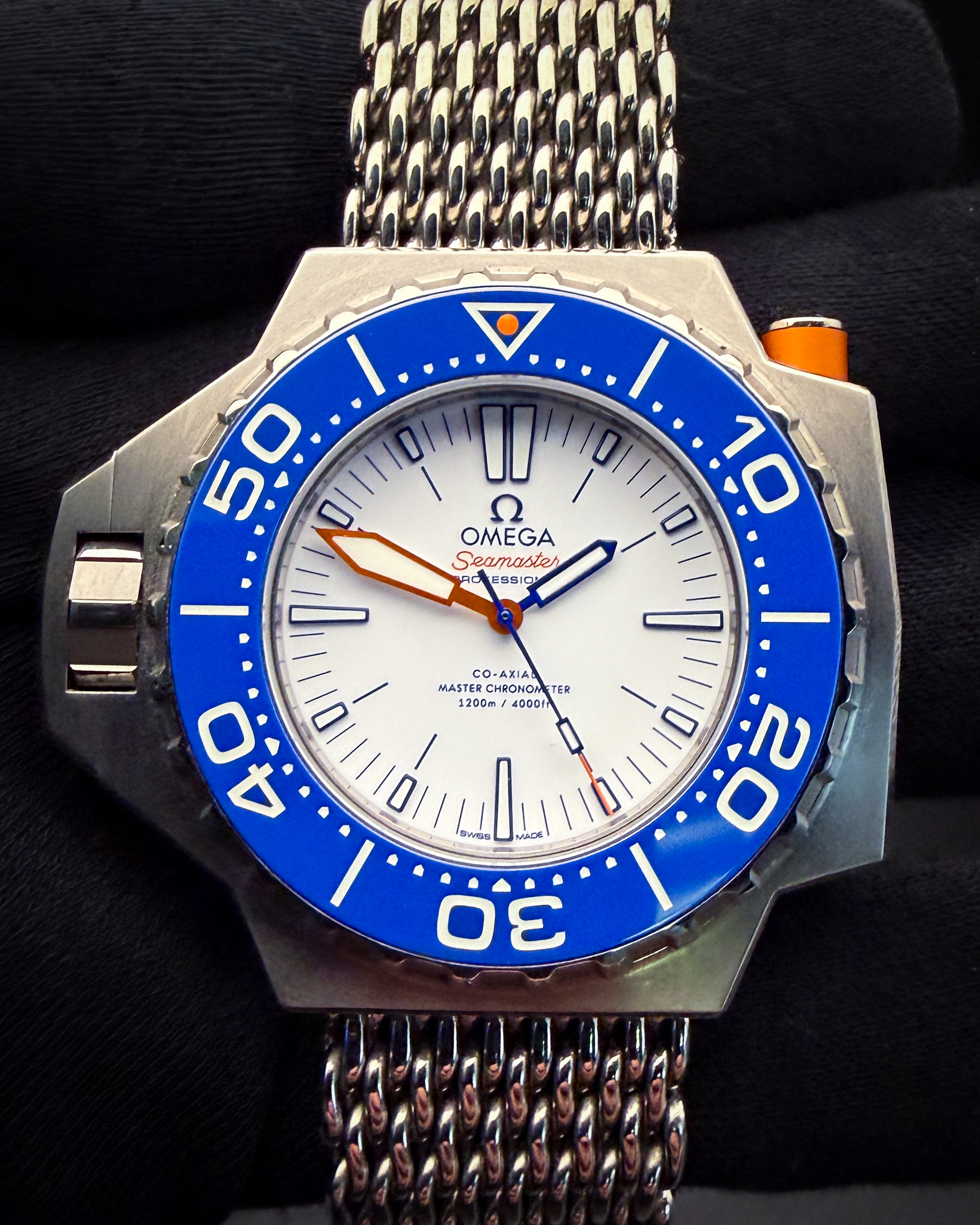 Omega PloProf 1200m Titanium 227.90.55.21.04.001 with the coveted white dial and blue ceramic bezel. This PloProf has been tested in excellent working order and is ready for daily wear or to be added to a collection. Includes: Outer box; inner case; blue strap; long and short titanium shark-mesh straps; instructions booklet; Pictogram card; Master Chronometer card; and International Warranty Card. Serial Number: 87713XXX