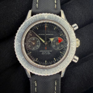 1960s Nivada Grenchen Chronomaster Aviator Sea Diver 1832M8222 — an original, honest example of one of the most versatile tool chronographs of the era. Powering this example is the revered Valjoux 92 hand-wound movement — a column-wheel chronograph caliber respected for its reliability, smooth actuation, and historical significance. This vintage Nivada is running wonderfully, keeping time and start/stop/reset. The caseback features five distinct service marks.