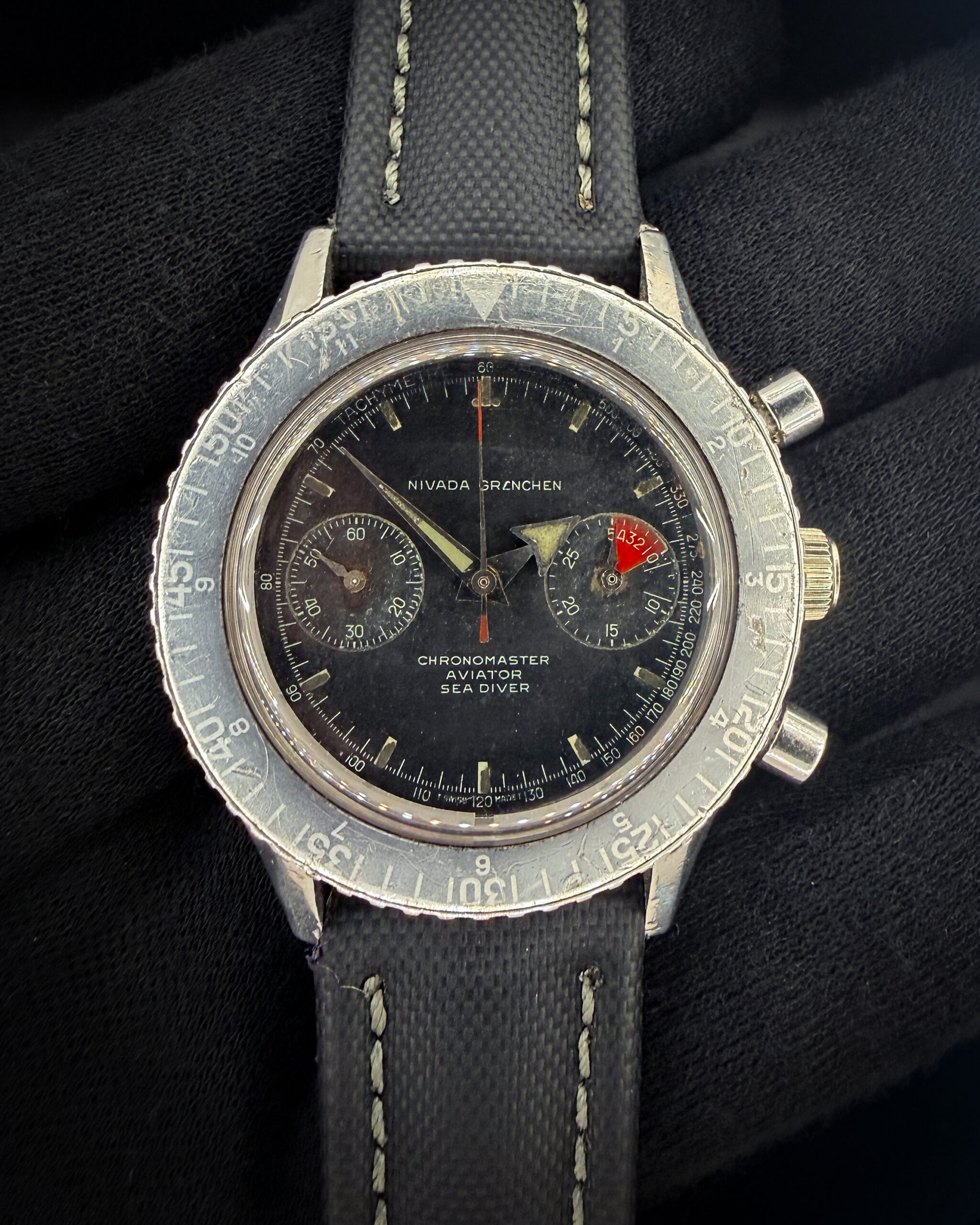 1960s Nivada Grenchen Chronomaster Aviator Sea Diver 1832M8222 — an original, honest example of one of the most versatile tool chronographs of the era. Powering this example is the revered Valjoux 92 hand-wound movement — a column-wheel chronograph caliber respected for its reliability, smooth actuation, and historical significance. This vintage Nivada is running wonderfully, keeping time and start/stop/reset. The caseback features five distinct service marks.