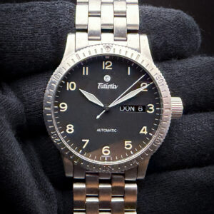 2000's Tutima FX Automatic Day-Date in a 38.5mm stainless steel case, powered by the ETA 2836-2 Automatic movement. This Tutima has been tested in good working order and is ready for daily wear. Case Serial Number: 63111XXX This early-generation Tutima FX Automatic Day-Date Ref. 631-04 features a 38.5mm brushed stainless-steel case, matching factory bracelet, black luminous Arabic dial and bidirectional 60-minute bezel. It is powered by the dependable 25-jewel ETA 2836-2 automatic movement with central seconds and day/date display beneath a domed sapphire crystal.