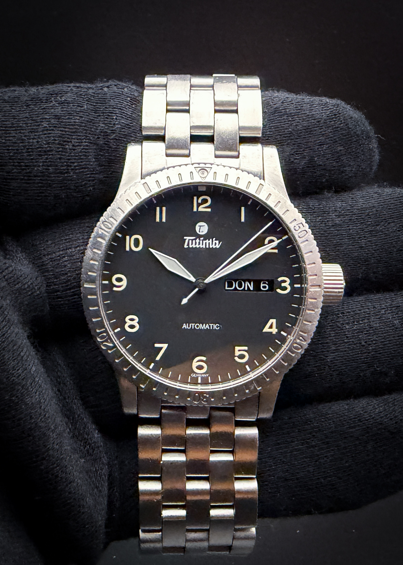 2000's Tutima FX Automatic Day-Date in a 38.5mm stainless steel case, powered by the ETA 2836-2 Automatic movement. This Tutima has been tested in good working order and is ready for daily wear. Case Serial Number: 63111XXX This early-generation Tutima FX Automatic Day-Date Ref. 631-04 features a 38.5mm brushed stainless-steel case, matching factory bracelet, black luminous Arabic dial and bidirectional 60-minute bezel. It is powered by the dependable 25-jewel ETA 2836-2 automatic movement with central seconds and day/date display beneath a domed sapphire crystal.