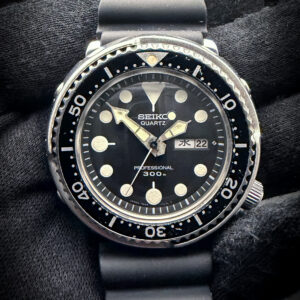 1979 Seiko Tuna Professional 300m Quartz 7549-7010 SBBN001 in a 47mm stainless steel case, featuring the JDM Kanji Day-wheel, powered by the Seiko 7549 quartz movement. This Tuna has been serviced and battery replaced in September 2026 and is ready for wear or to be added to a collection. Case Serial Number: 921235 The sapphire crystal is clear and free of scratches or edge-chips. The original dial and hands are beautiful, with a nice patina to the original lume. The dial has no significant discoloration or stains. Overall the case is in good, vintage condition, with marks consistent with use. The bezel rotates and clicks as designed. This Seiko is paired with a new, unworn Seiko 22mm Diver rubber dive strap, with Seiko stainless steel buckles and keeper.
