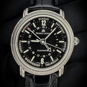 The Maurice Lacroix Masterpiece Cinq-Aiguilles MP6328 combines classic Swiss craftsmanship with a distinctive five-hand display. Its 40mm stainless steel case frames a black dial with luminous hands and hour markers, bold Arabic numerals at twelve and six, and dedicated central pointers indicating the date and day of the week. Named “Cinq-Aiguilles,” French for “five hands,” the design presents hours, minutes, seconds, day, and date entirely through centrally mounted hands. Power comes from the decorated, 25-jewel ML27 automatic movement, visible through the exhibition case back, while a sapphire crystal protects the dial. This example is fitted with a new black leather strap paired with its original Maurice Lacroix buckle, completing its elegant and individual character.