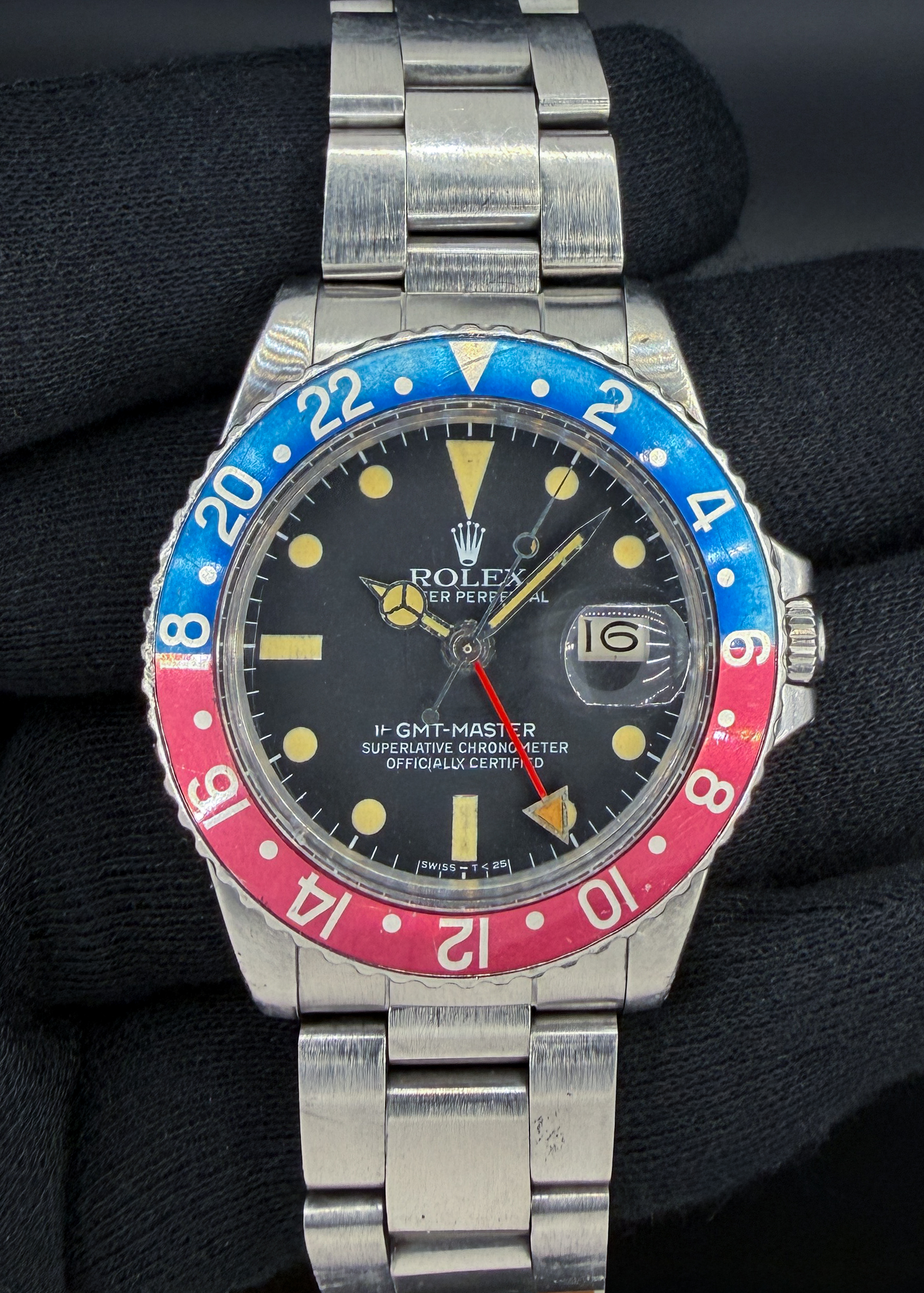 Offered is a highly desirable, early-production Rolex GMT-Master Ref. 16750 "Pepsi," dating to circa 1980, serial number 6,303,XXX. This collectible transitional GMT-Master features a genuine Rolex matte black tritium dial with beautifully preserved yellow-cream hour markers, aged tritium hands, and a striking faded blue-and-red aluminum bezel insert. The dial retains its vintage matte finish, and its manufacturer's markings were inspected during the recent professional movement service. The stainless steel 40mm Oyster case is accompanied by a genuine Rolex Oyster bracelet, reference 78360, fitted with the correct 580 end links. Powered by the reliable Rolex caliber 3075 automatic movement, featuring a quickset date and 28,800 bph frequency, the watch has recently been professionally serviced, including installation of a new mainspring and acrylic crystal. The dial, hands, bezel, and other vintage cosmetic components have been preserved, maintaining the watch's authentic period appearance. The case and bracelet exhibit age-appropriate wear. With its early 6.3-million serial number, desirable matte tritium dial, beautifully developed patina, and period-correct Rolex Oyster bracelet, this GMT-Master offers an outstanding combination of vintage Rolex collectibility and everyday functionality. Accuracy Testing: +5 SPD / 258 Amplitude / .4ms Beat Error Case Serial Number: 6303XXX This Rolex is paired with the Rolex Oyster 78360 Stainless steel bracelet with 580 end-links. The bracelet has two (2) removable links currently installed and will fit up to a 7.5 inch wrist. 