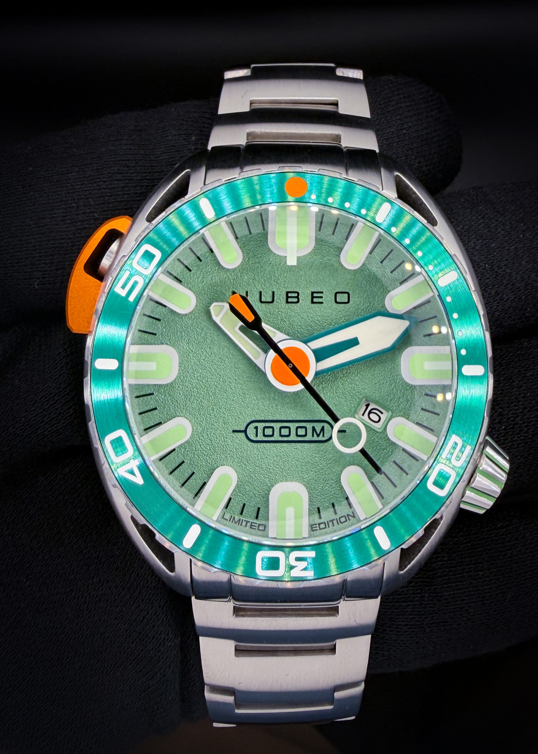 Nubeo Aluminaut Automatic “Sea Green” NB-6115-99 – Limited Edition #033/120 The Nubeo Aluminaut “Sea Green” takes its inspiration from the historic Aluminaut deep-sea research submarine. Its substantial 50mm stainless steel case frames a textured green dial with oversized luminous hour markers, bold hands, and contrasting orange accents. A coordinating green dive bezel completes its distinctive appearance. Powered by a Japanese automatic movement with a date display, the Aluminaut features an anti-reflective sapphire crystal, screw-down crown, helium release valve, and a factory water-resistance rating of 1,000 meters. The case measures 22mm thick and 55mm from lug to lug, giving this model considerable wrist presence.